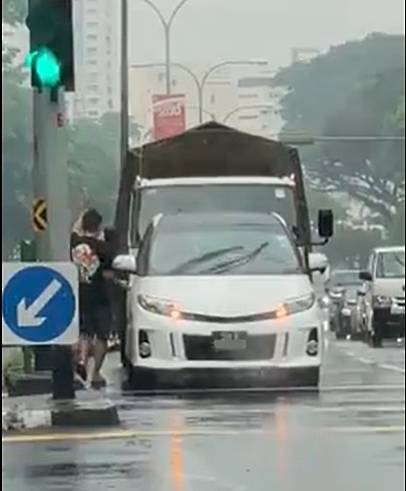 热心男交通灯前停车·冒雨推坐轮椅长者过马路 