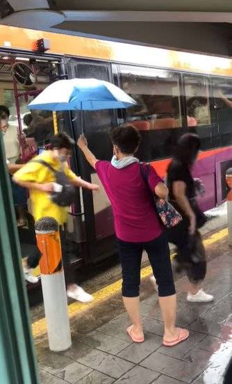 雨天溫馨一幕 阿嫂爲乘客撐傘